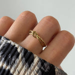 Gros plan bague Alberta motif nœud marin ou nœud d'amour portée au doigt.