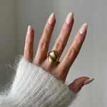 Gros plan bague Alexandra style sculptural et bombé portée au doigt, bijou moderne et artistique.