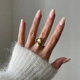 Gros plan bague Alexandra style sculptural et bombé portée au doigt, bijou moderne et artistique.