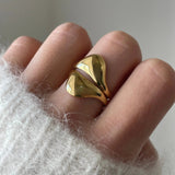 Gros plan bague Alexandra style sculptural et bombé portée au doigt, bijou moderne et artistique.