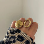 Bague géométrique Alina portée en accumulation avec une bague dôme dorée pour un look audacieux.