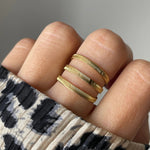 Gros plan bague Amandina effet accumulation trois anneaux ciselés portée au doigt, style moderne.