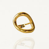 Bague large géométrique forme cercle organique et évidé en acier inoxydable doré sur fond blanc.