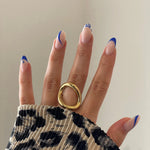 Gros plan bague Anastasia au design cercle irrégulier et moderne portée au doigt.