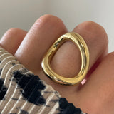 Gros plan bague Anastasia au design cercle irrégulier et moderne portée au doigt.