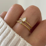 Gros plan bague Anna style accumulation 2-en-1 portée au doigt avec pierre effet nacre.