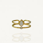 Bague ouverte effet double rang en acier inoxydable doré avec pierre blanche forme goutte et petit cristal.