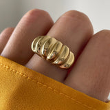 Gros plan bague Aurora forme bombée et striée portée au doigt, style vintage chic.