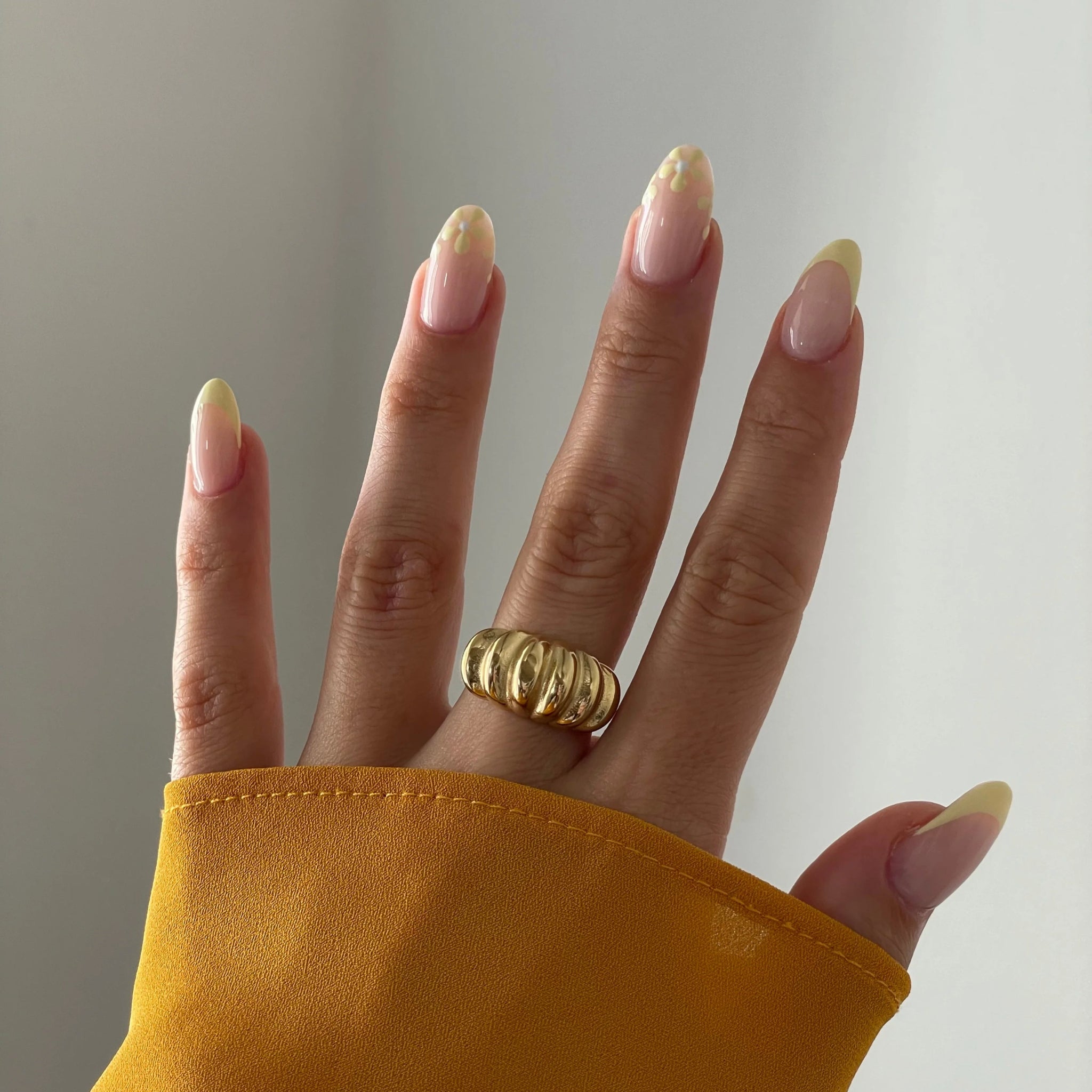 Gros plan bague Aurora forme bombée et striée portée au doigt, style vintage chic.