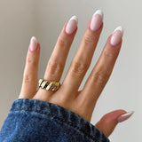 Bague Berenice motif torsades en relief portée au doigt avec veste en jean, style chunky tendance.