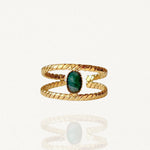 Bague ouverte double rang effet torsadé en acier inoxydable doré avec pierre ovale verte sur fond blanc.