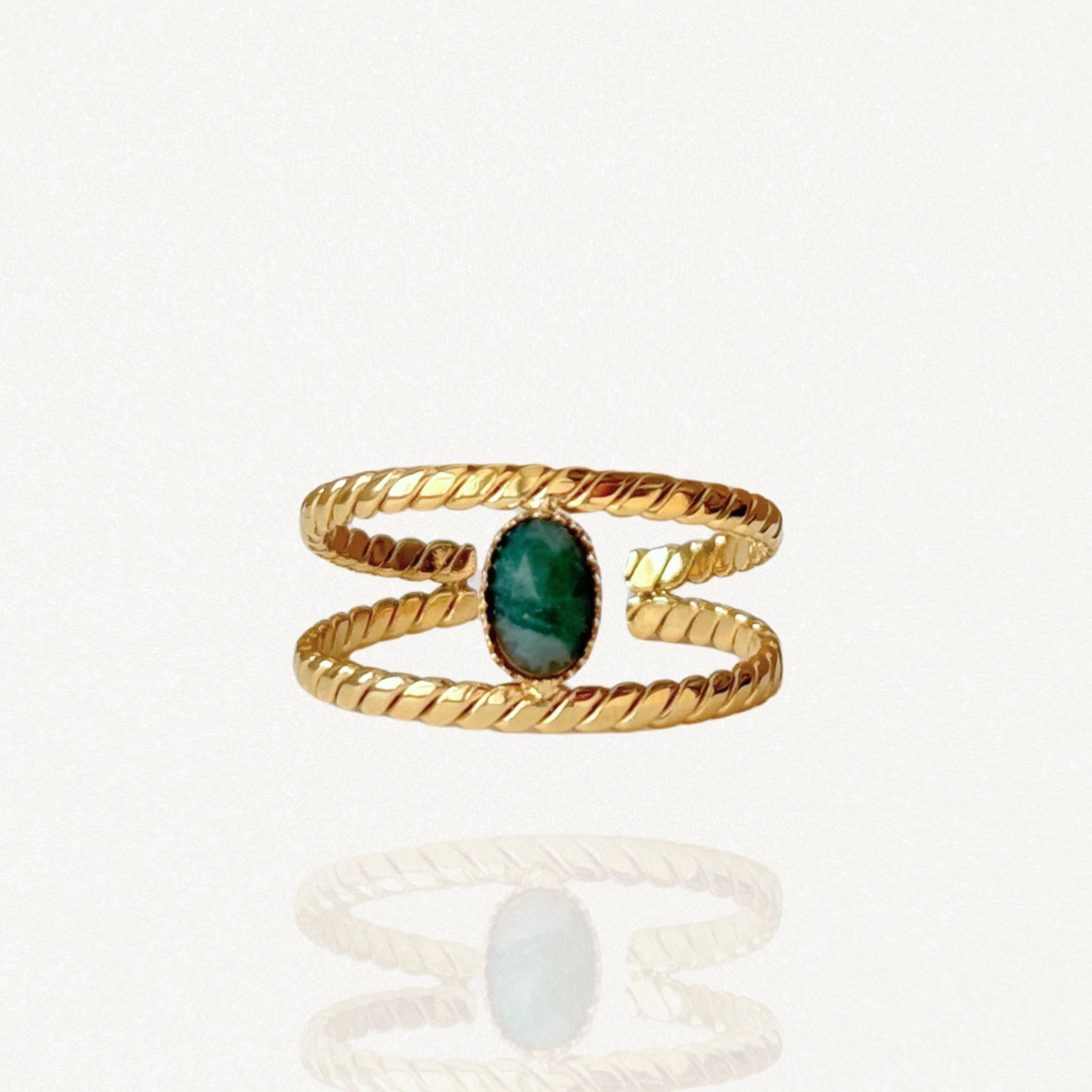 Bague ouverte double rang effet torsadé en acier inoxydable doré avec pierre ovale verte sur fond blanc.