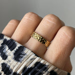 Gros plan bague Ceyda dorée à relief texturé portée au doigt, style ethnique chic.