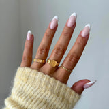 Gros plan bague Christina avec pierre rectangulaire sertie à l'horizontale portée au doigt, style discret et raffiné.