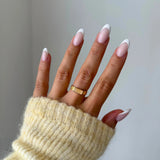 Gros plan bague Christina avec pierre rectangulaire sertie à l'horizontale portée au doigt, style discret et raffiné.