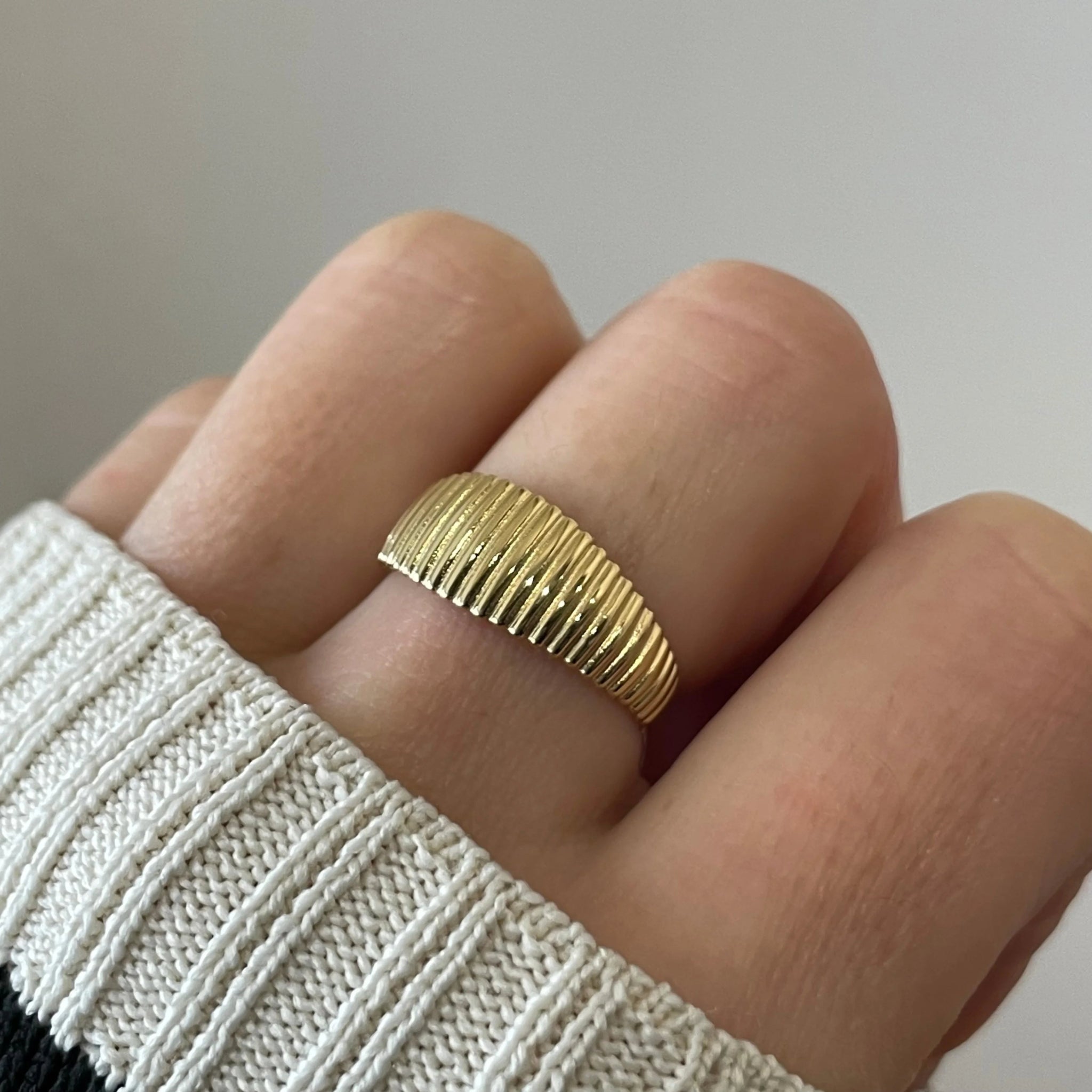 Gros plan bague Claudia à relief côtelé et bombé portée au doigt, style rétro chic.