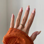 Gros plan bague Dakota motif chaîne minimaliste portée au doigt, style intemporel.