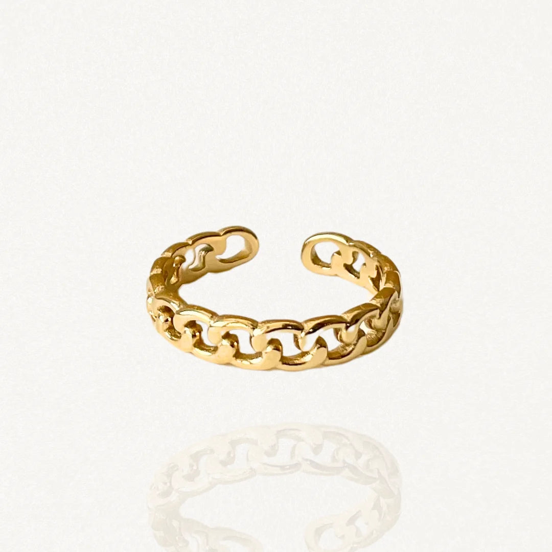 Bague fine ouverte en acier inoxydable doré avec motif chaîne maillons gourmette sur fond blanc.