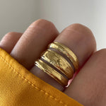 Gros plan bague Ella à trois anneaux soudés style accumulation portée au doigt.