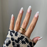 Bague double rangs Filipa portée en accumulation avec une bague cercle géométrique sur main manucurée avec pull léopard.