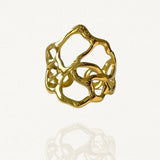 Bague large ajourée en acier inoxydable doré au design organique et irrégulier évoquant des végétaux entrelacés.