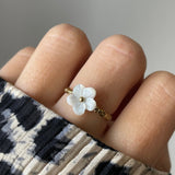 Bague Florina motif fleur portée sur une main manucurée avec pull léopard, style tendance.