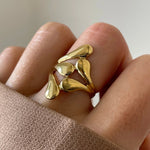 Gros plan bague Ilona motif gouttes de pluie style 'liquid metal' portée au doigt, design moderne.