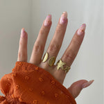 Bague coquillage Jana portée en accumulation (stacking) avec une bague étoile de mer pour un look sirène complet.