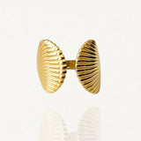 Bague ouverte ajustable en acier inoxydable doré avec motif double coquillage Saint-Jacques strié sur fond blanc.