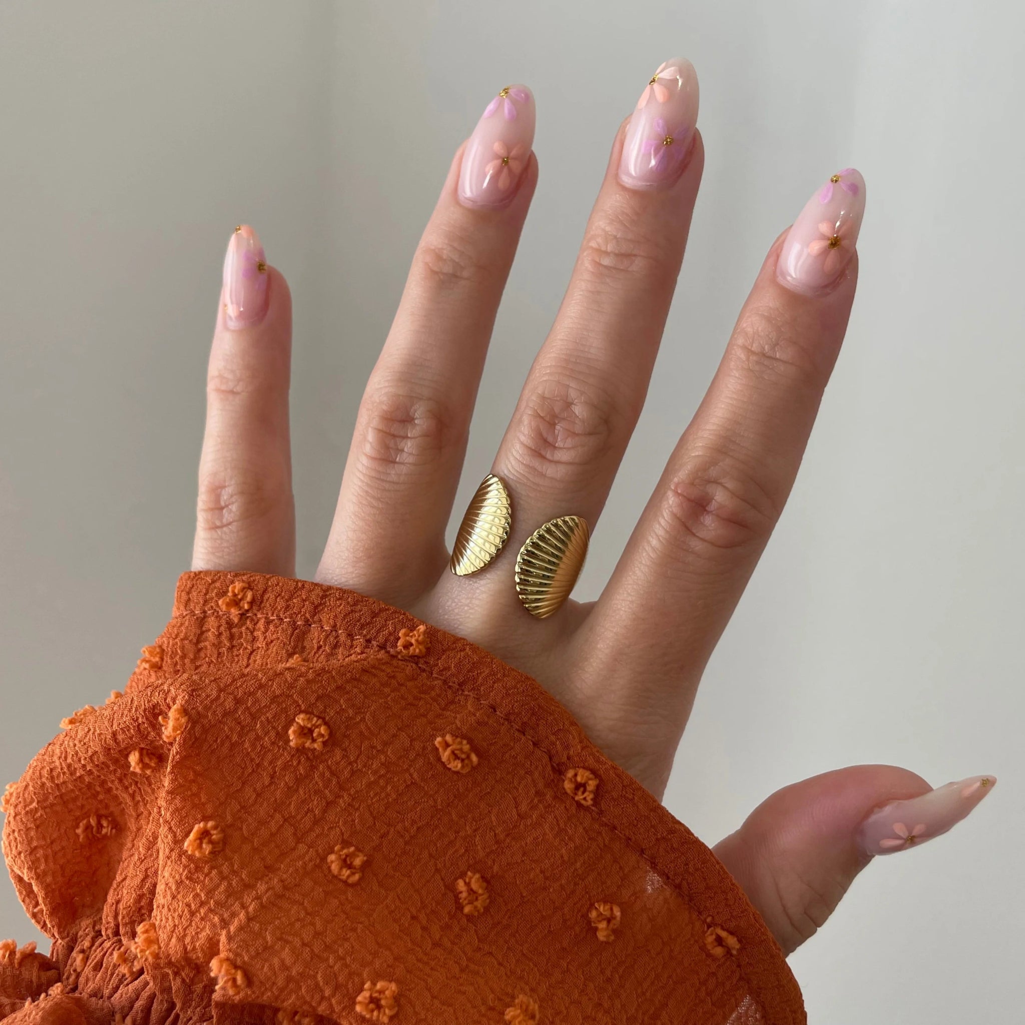 Bague coquillage Jana portée en accumulation (stacking) avec une bague étoile de mer pour un look sirène complet.