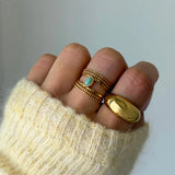 Bague multi-rangs Jessica portée en accumulation (stacking) avec une grosse bague dôme dorée lisse.