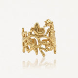 Bague en acier inoxydable doré, motif marin avec hippocampe, coquillage et étoiles de mer sur fond corallien.