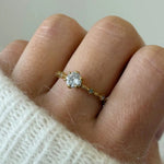 Gros plan bague fine Léonie avec petit cristal solitaire portée au doigt, style délicat et romantique.