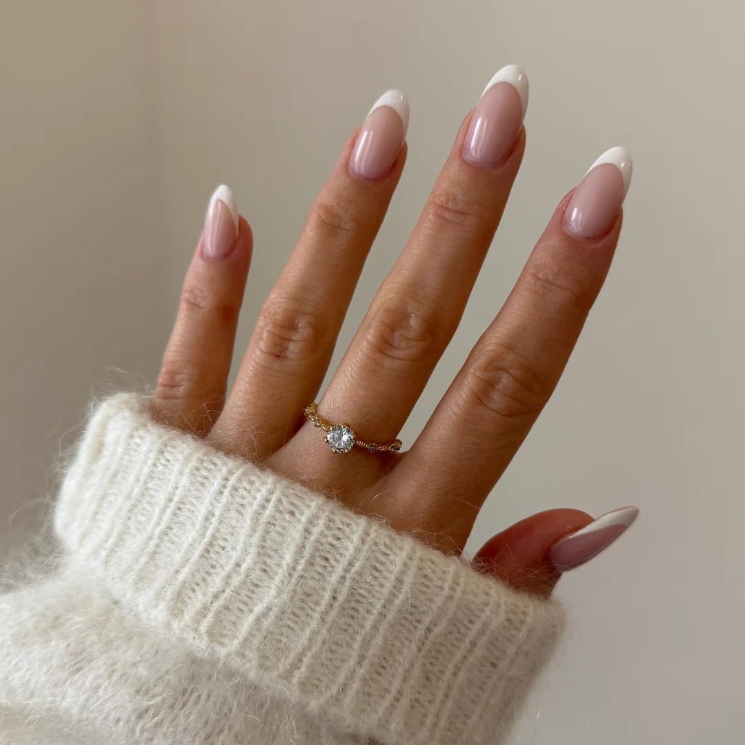 Bague fine à pierre Léonie portée en accumulation (stacking) avec d'autres bagues dorées minimalistes sur une main.