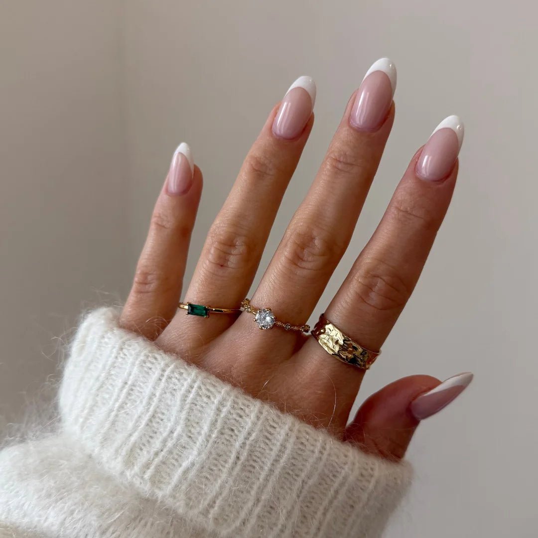 Bague fine à pierre Léonie portée en accumulation (stacking) avec d'autres bagues dorées minimalistes sur une main.