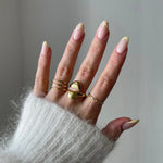 Bague fine Louisa portée en accumulation (stacking) pour accompagner une grosse bague cœur doré.