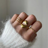 Bague fine Louisa portée en accumulation (stacking) pour accompagner une grosse bague cœur doré.