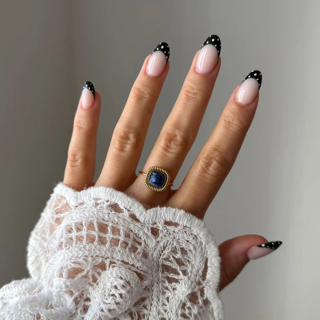 Gros plan bague Lucie style vintage avec pierre bleue marine forme coussin portée au doigt, accessoire chic et intemporel.