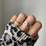 Bague fine Lucrecia portée en accumulation (stacking) avec la bague fleur Florina pour un look romantique.