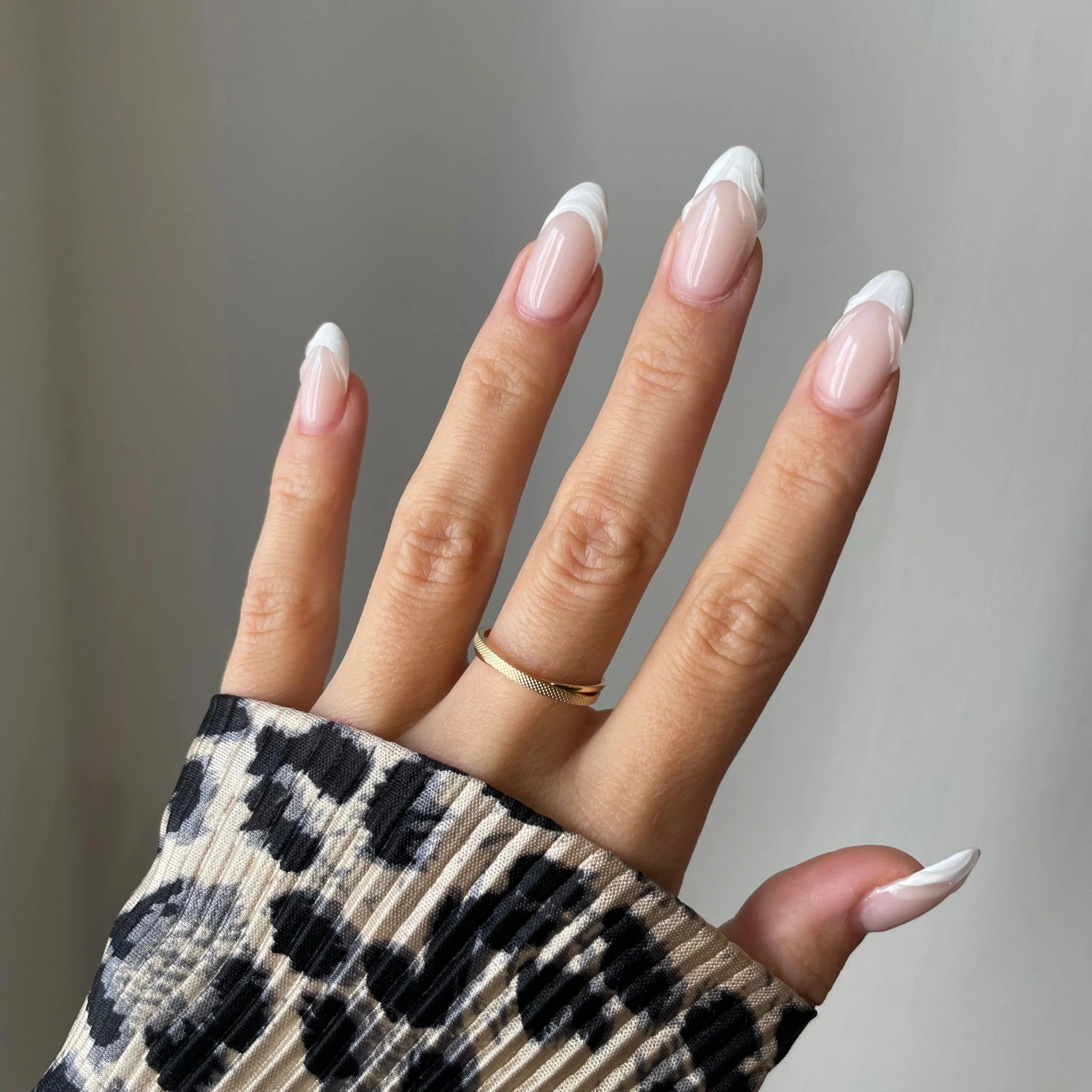 Gros plan bague Lucrecia effet croisé et texturé portée au doigt, bijou minimaliste et lumineux.