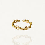 Bague fine ouverte ajustable en acier inoxydable doré avec motif chaîne de nœuds entrelacés sur fond blanc.