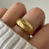 Gros plan bague Marta au volume bombé portée au doigt, design minimaliste et audacieux (chunky).