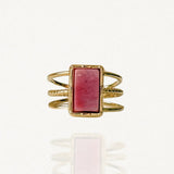Bague large multi-rangs en acier inoxydable doré ornée d'une pierre naturelle rectangulaire rose vieux rose (style rhodonite) sur fond blanc.