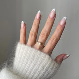 Bague fine Melania portée en accumulation (stacking) avec d'autres bagues dorées et perles sur une main manucurée.