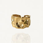 Bague large ajustable en acier inoxydable doré avec effet martelé et texturé sur fond blanc.