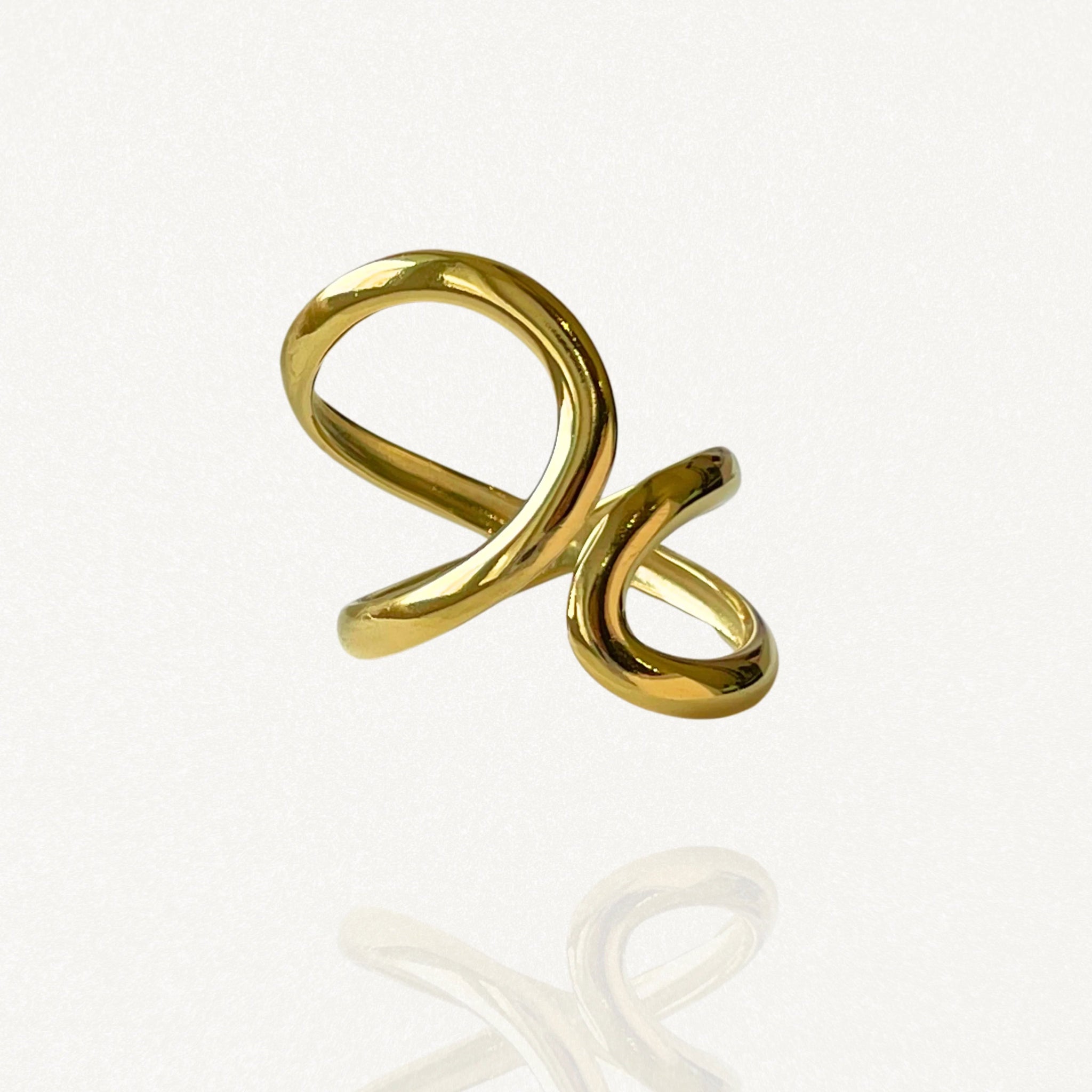 Bague ouverte ajustable en acier inoxydable doré avec lignes courbes entrelacées et design graphique.