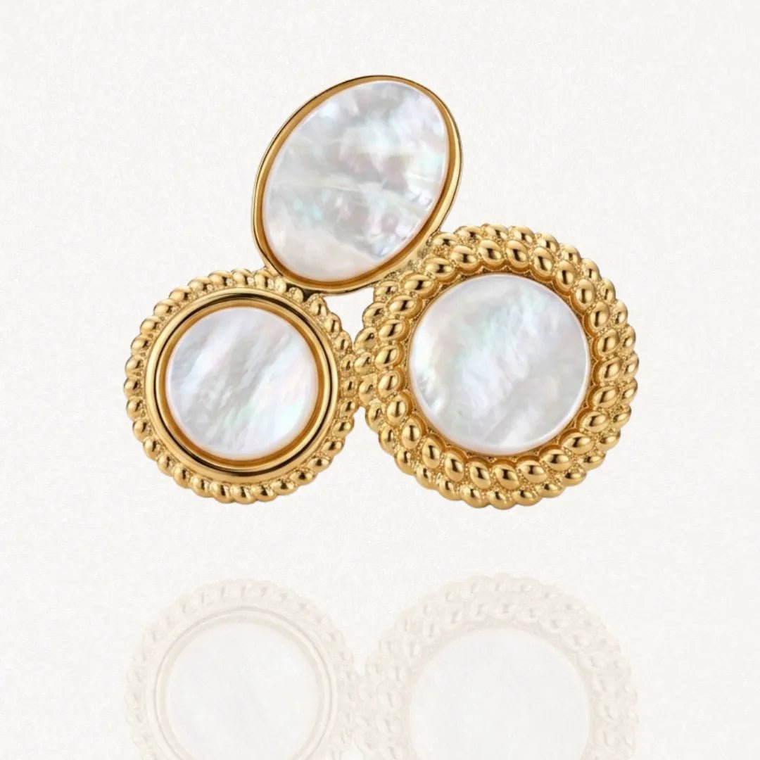 Bague MURIELLE dorée en acier inoxydable, composée de trois médaillons incrustés de résine blanche irisée, un ovale et deux ronds texturés.