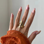 Bague longue Nicola sur une main avec manche rouille.