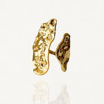 Bague statement allongée en acier inoxydable doré avec deux plaques irrégulières effet martelé sur fond blanc.