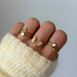 Bague double rang Ornella portée en accumulation (stacking) avec d'autres bagues fines et pierres blanches.